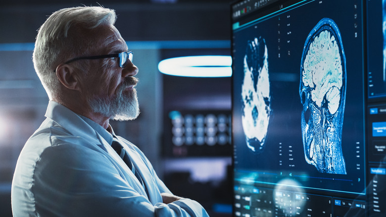 male medical personnel looking at brain scan