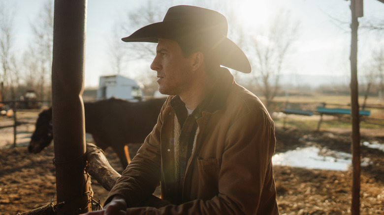 A cowboy relaxing at a ranch