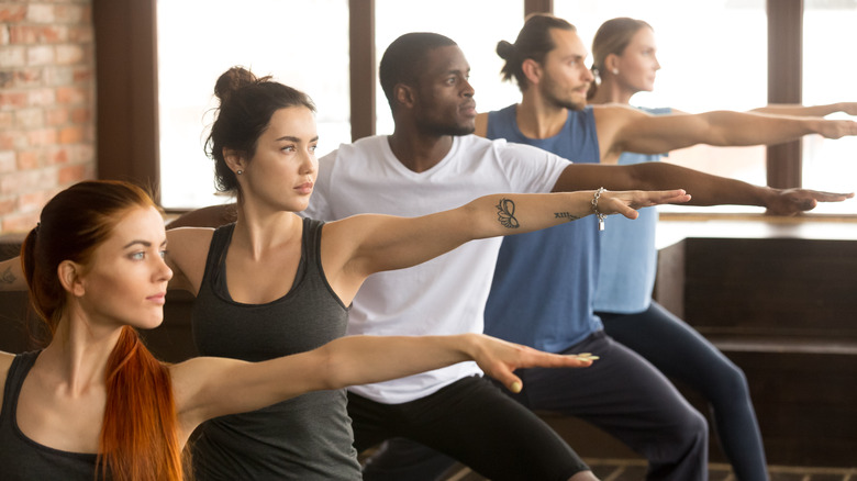 group of yoga students doing warrior 2 pose