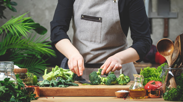 A woman's hands chopping broccoli