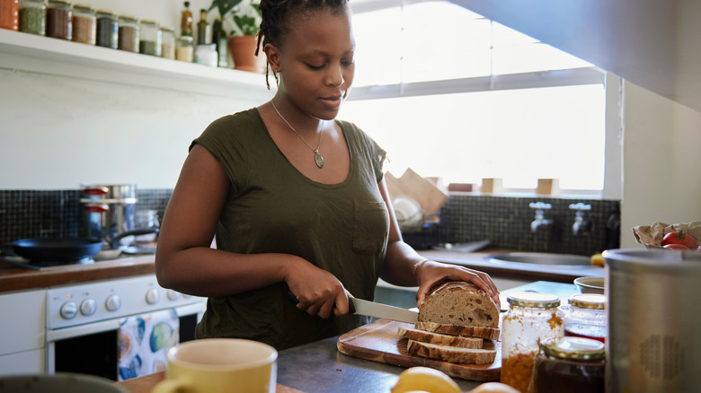 Woman slicing whole grain bread