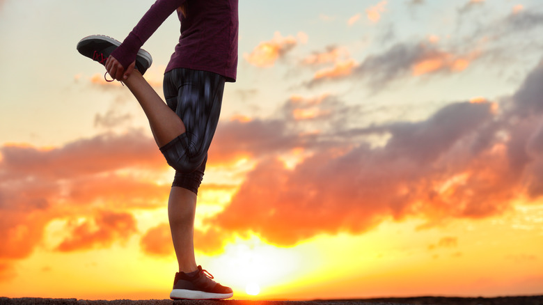 woman stretching at sunset