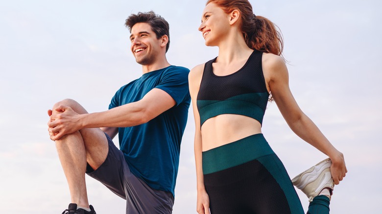 Man and woman in activewear stretching