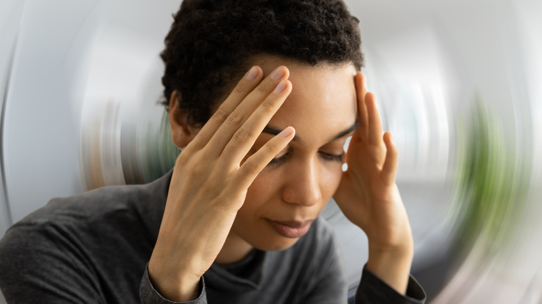 woman with vertigo holding head