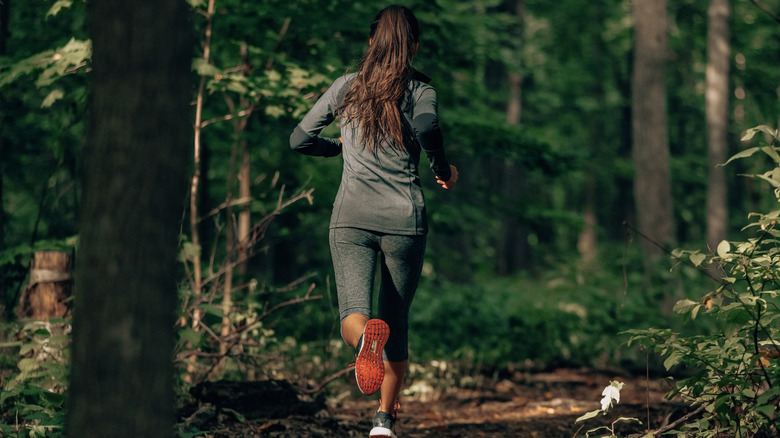 woman running among trees