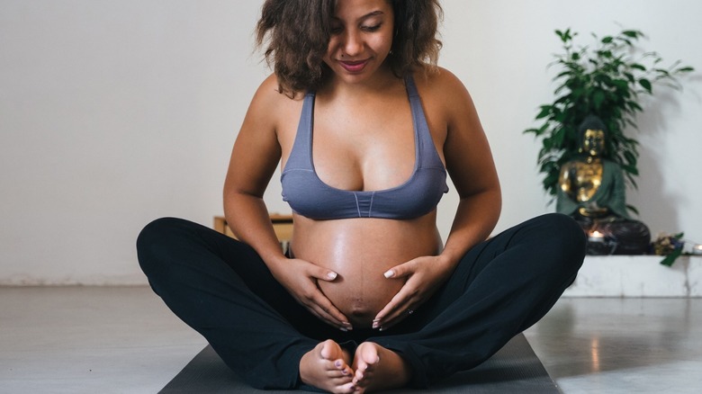 Pregnant woman stretching on mat