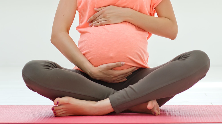 pregnant woman on yoga mat