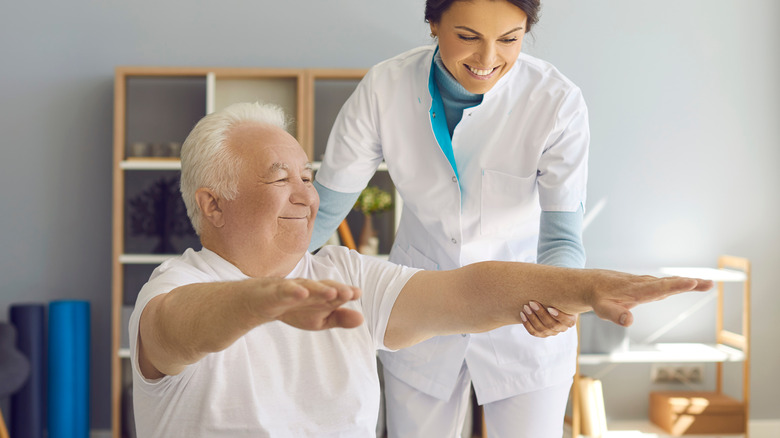 man doing exercise with healthcare professional