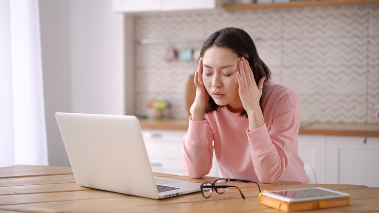 Woman at laptop with headache