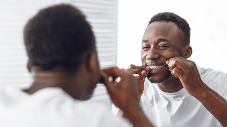 Smiling man flossing