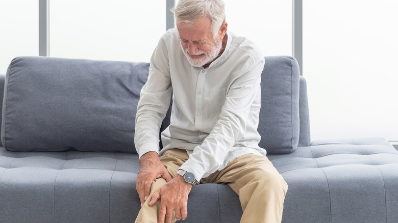 elderly white pain holding his knee because of osteoporosis pain