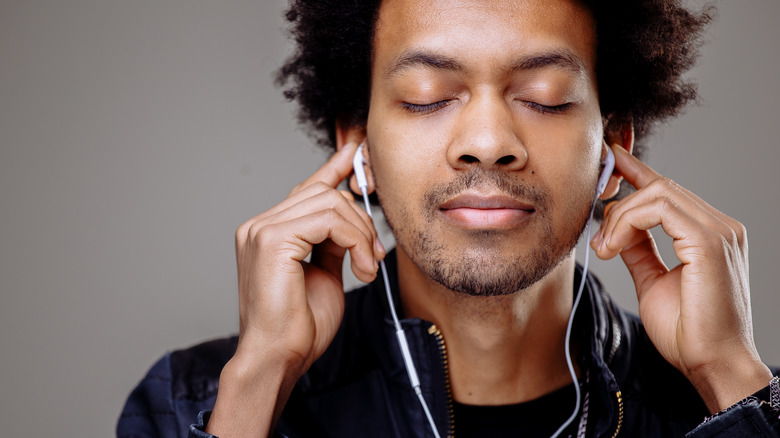 Man with closed eyes listening to headphones