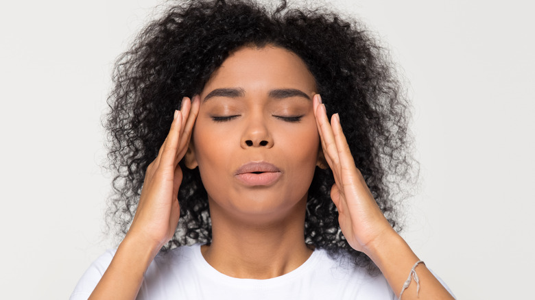 woman rubbing temples