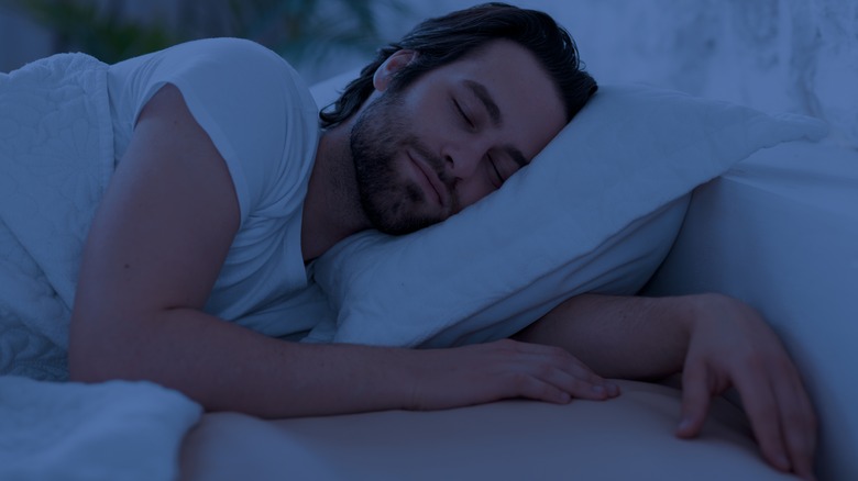 Smiling man asleep in bed