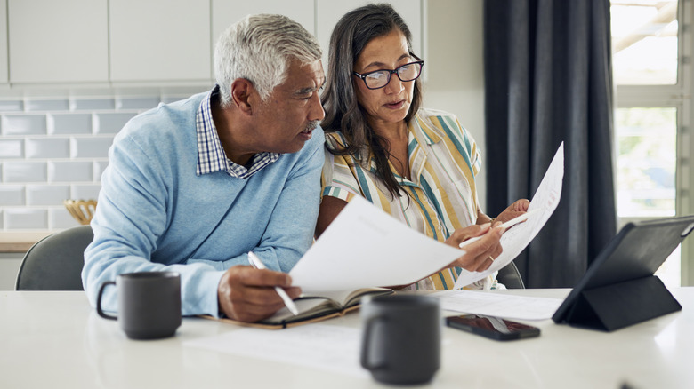 mature couple looking at financial documents at home