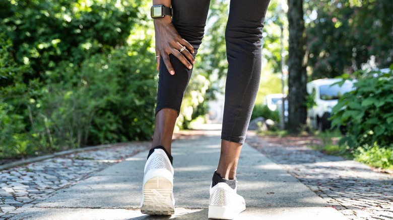 Female runner holds calf