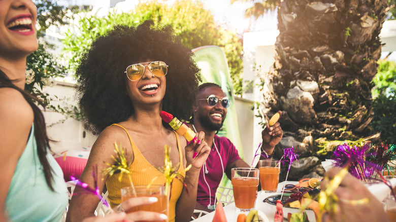 a group of people enjoying a summer gathering with food