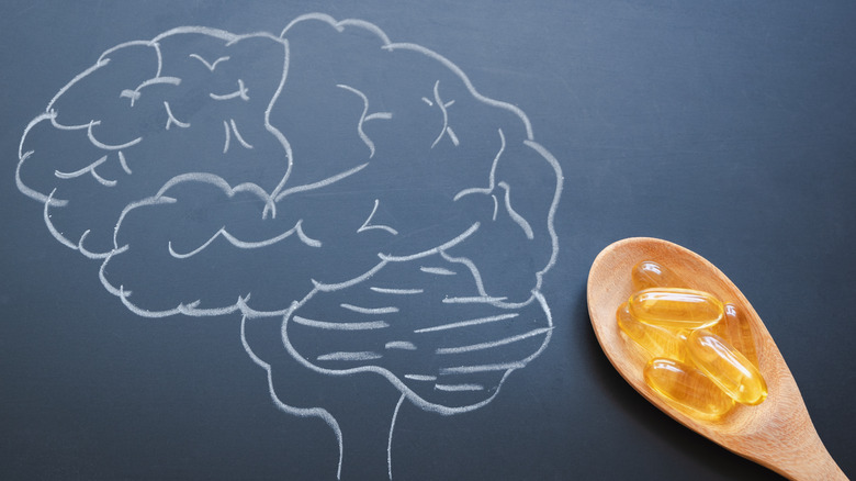 chalk drawing of brain and spoon of supplements