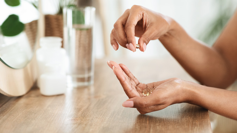 Unrecognizable African Woman Taking Supplements, Holding Capsules In Hands
