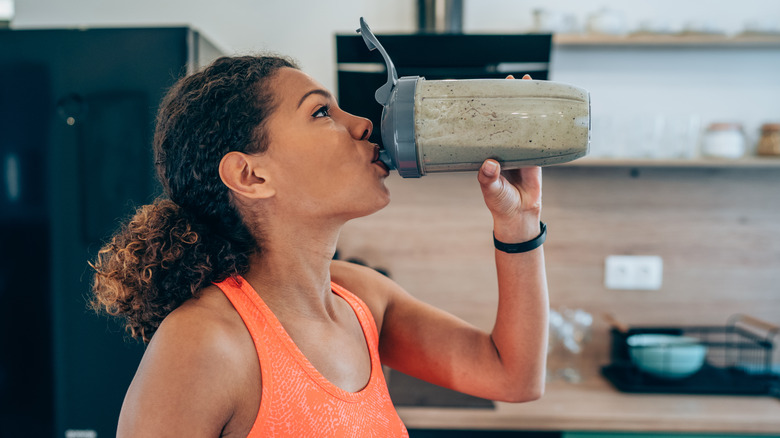 woman drinking a protein shake at home