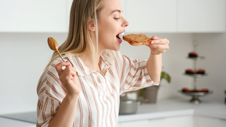 woman eating whole grain toast with nut butter