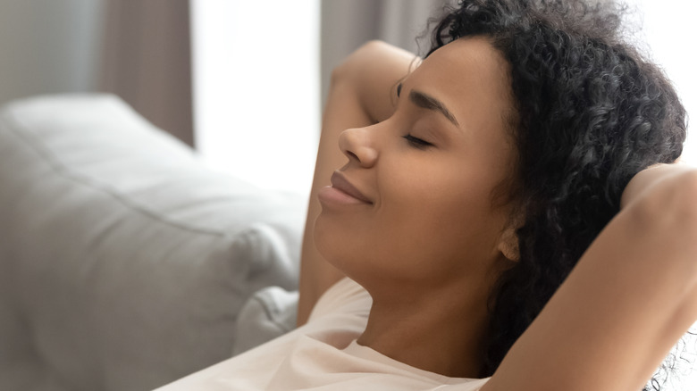 Close up of woman with closed eyes napping on couch