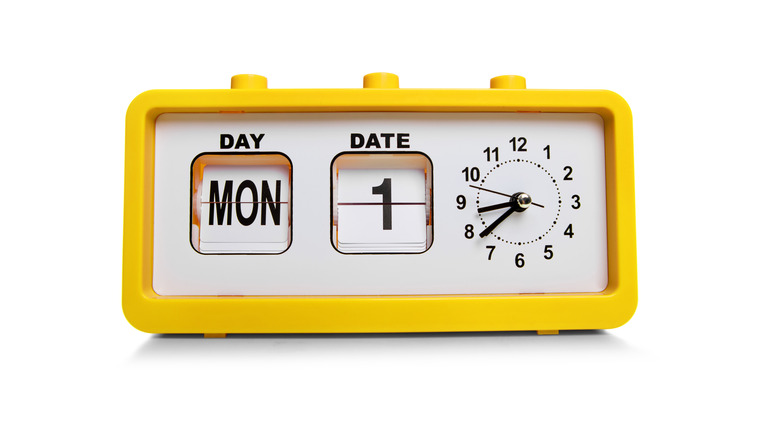 a yellow digital clock showing both the date and the time 