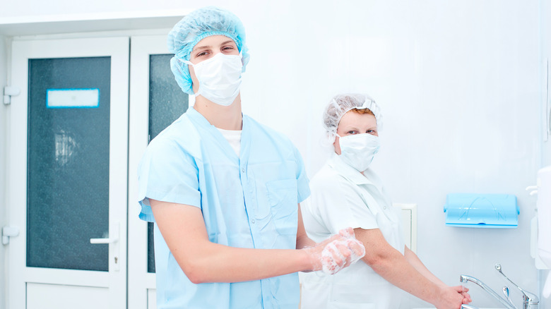 staff sterilizing their arms and hands post op 