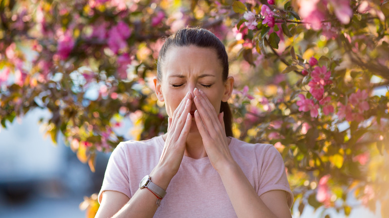 Woman sneezing outside