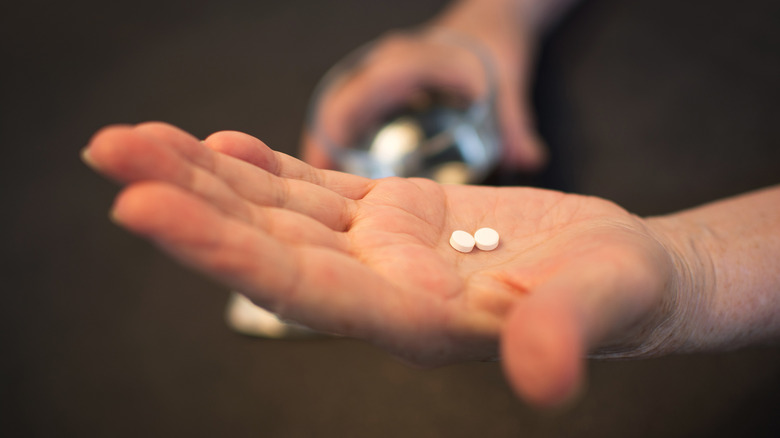 aspirin tablets in hand