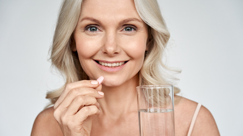 Woman taking pill with water
