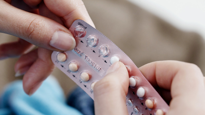 Woman's hand holding birth control