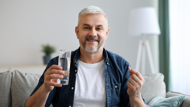 smiling man holding pill