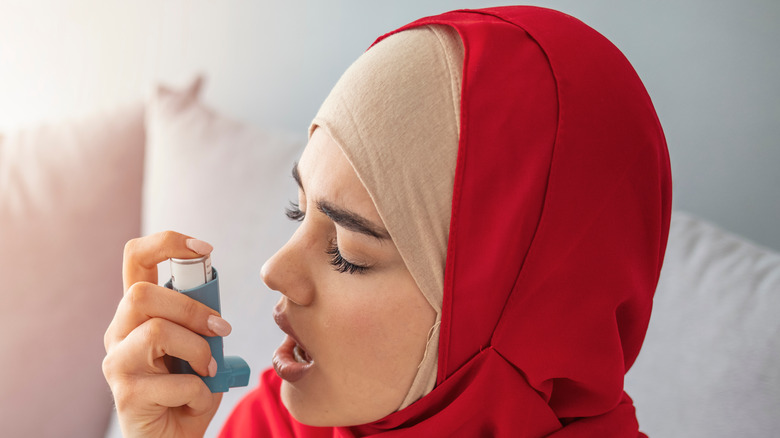 Woman with eyes closed preparing to breath through an inhaler