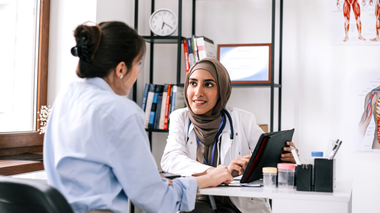 woman talking with doctor about leg cramps