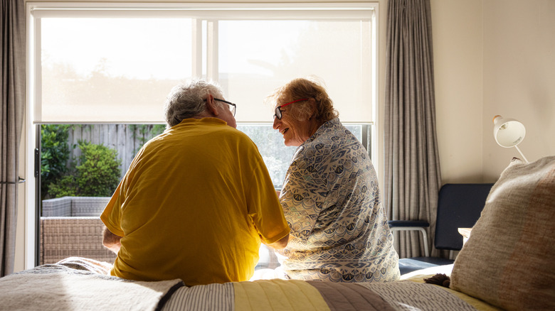 older couple sitting on side of bed