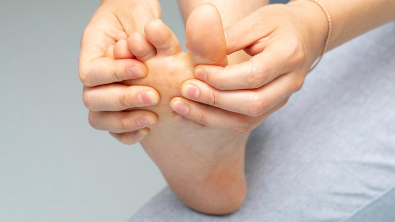 Close up of woman with athlete's foot spreading her toes