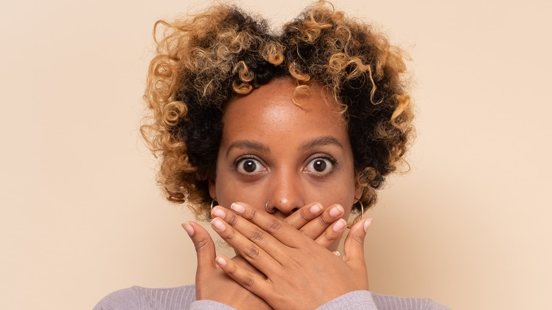 woman covering mouth
