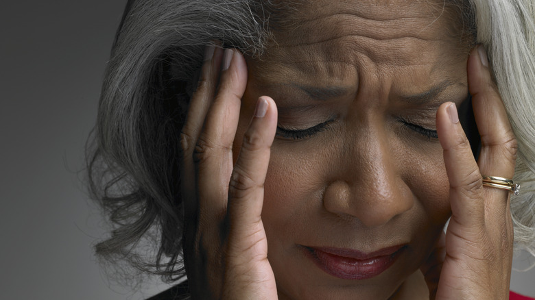 A woman holding her head in pain