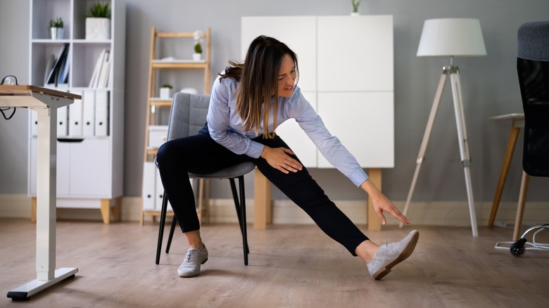 woman in a chair stretching her hamstrings