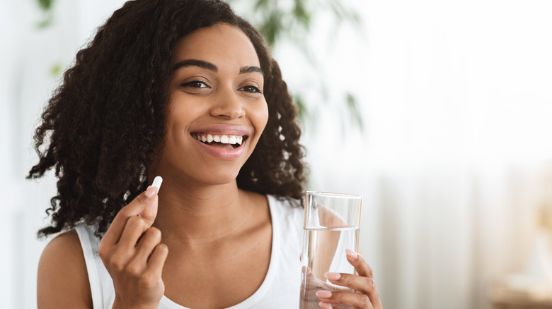 A woman is taking a biotin supplement