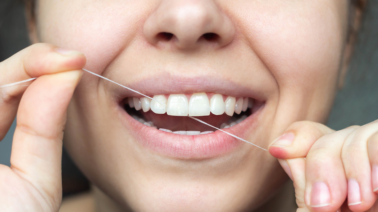 woman flossing her teeth