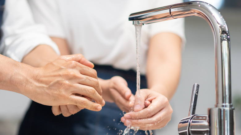 Cleaning hands under running water