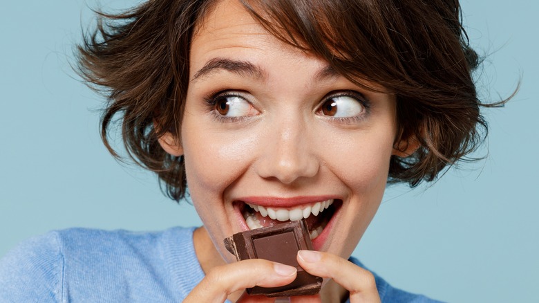 woman eating a square of chocolate