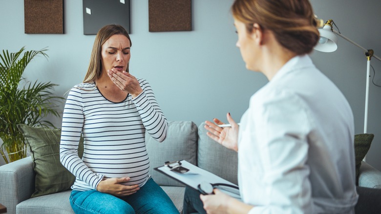 Pregnant woman sneezing in doctor's office