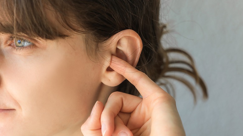 woman with finger in ear