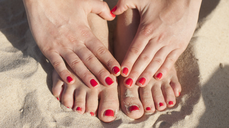 Painted toenails and fingernails at beach