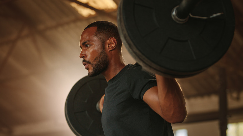 Man with barbell on back