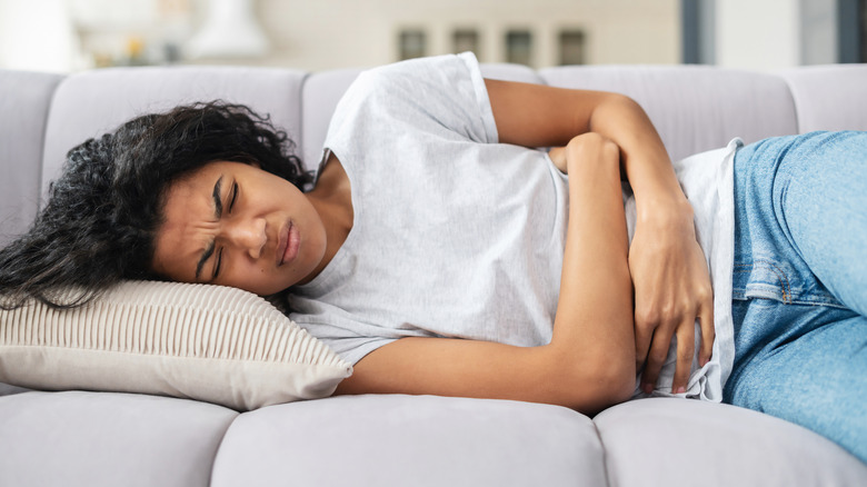 Woman lying on couch with cramps