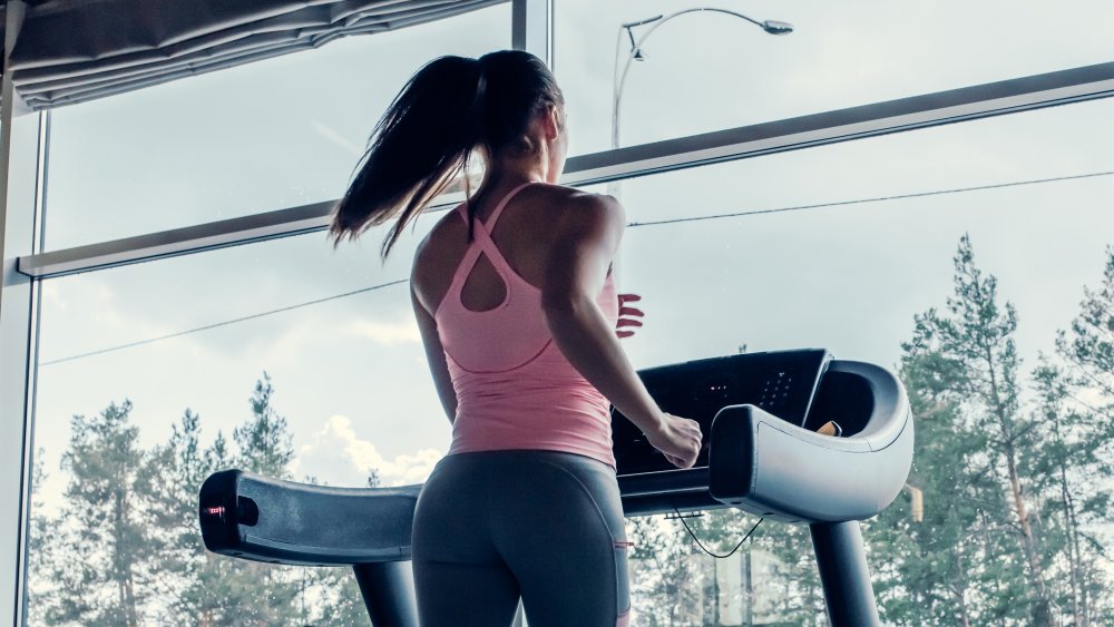 woman running on the treadmill while looking outside